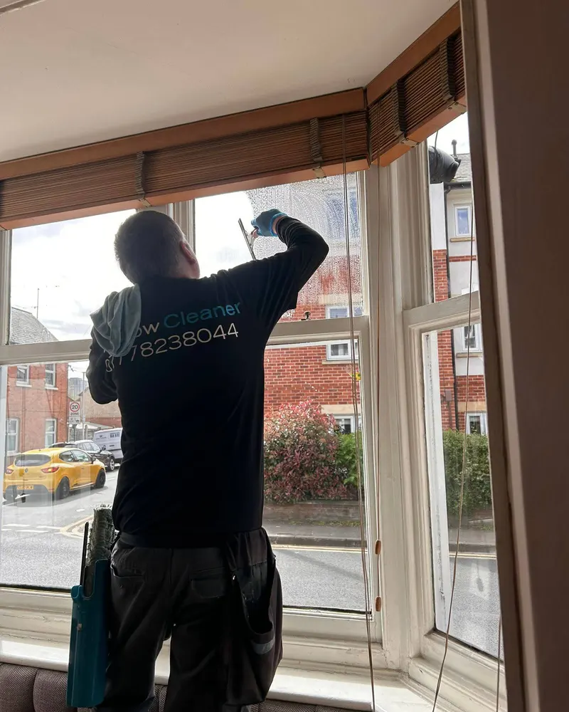 Stephen cleaning the inside of a bay window