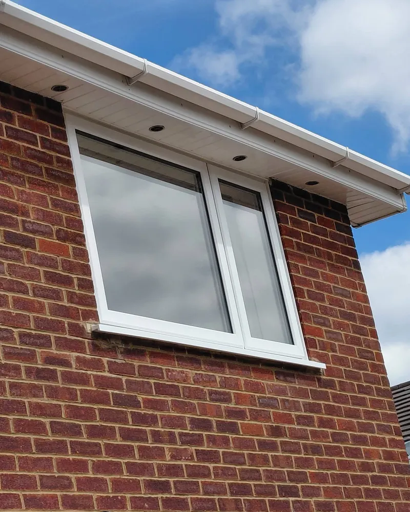 Clean white soffit and window frame on a brick house