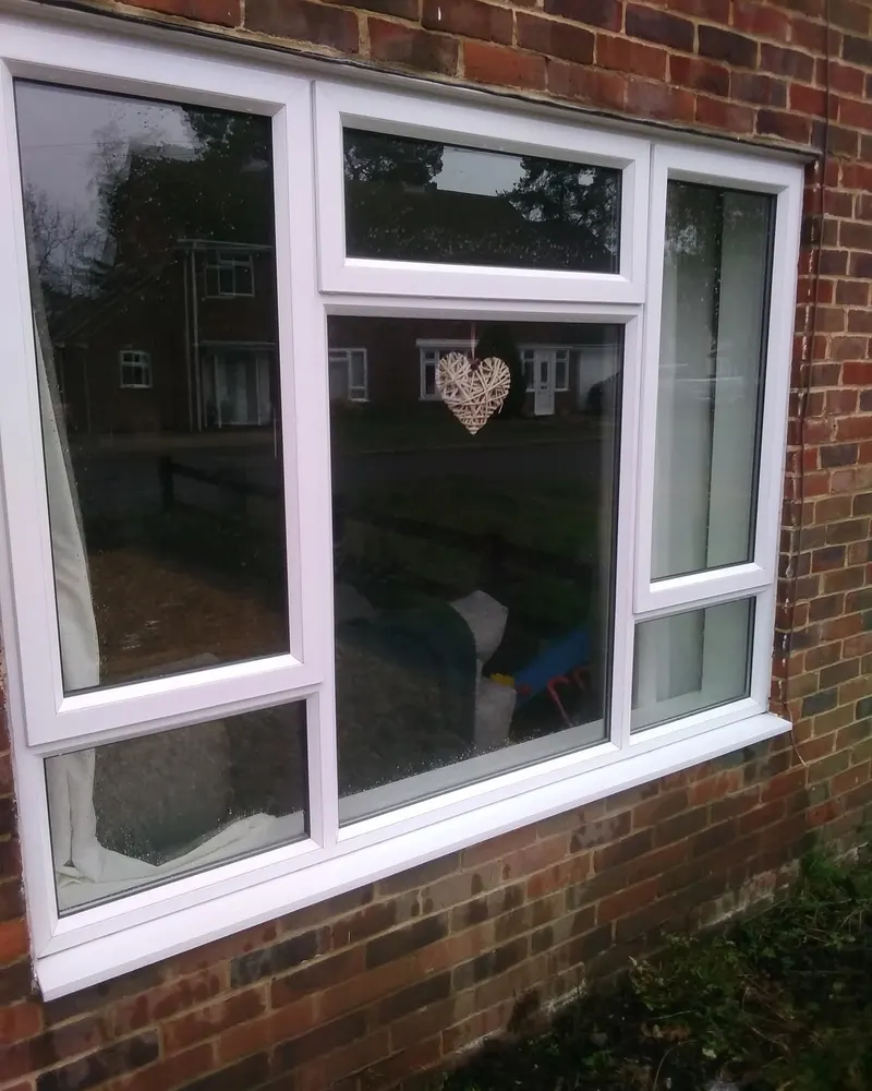 Clean white uPVC window in a brick wall